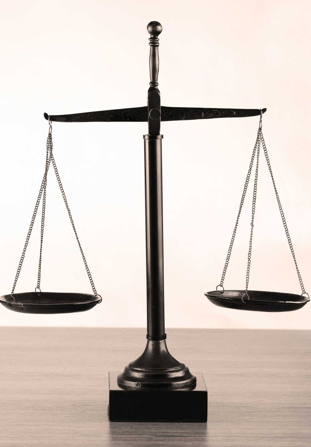 A black and white photo of a balance scale
Description automatically generated