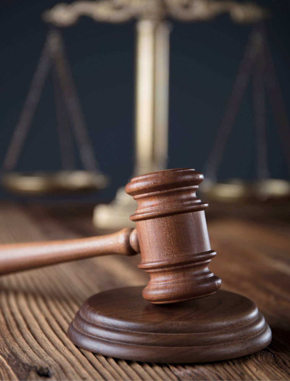 A gavel on a wooden stand
Description automatically generated